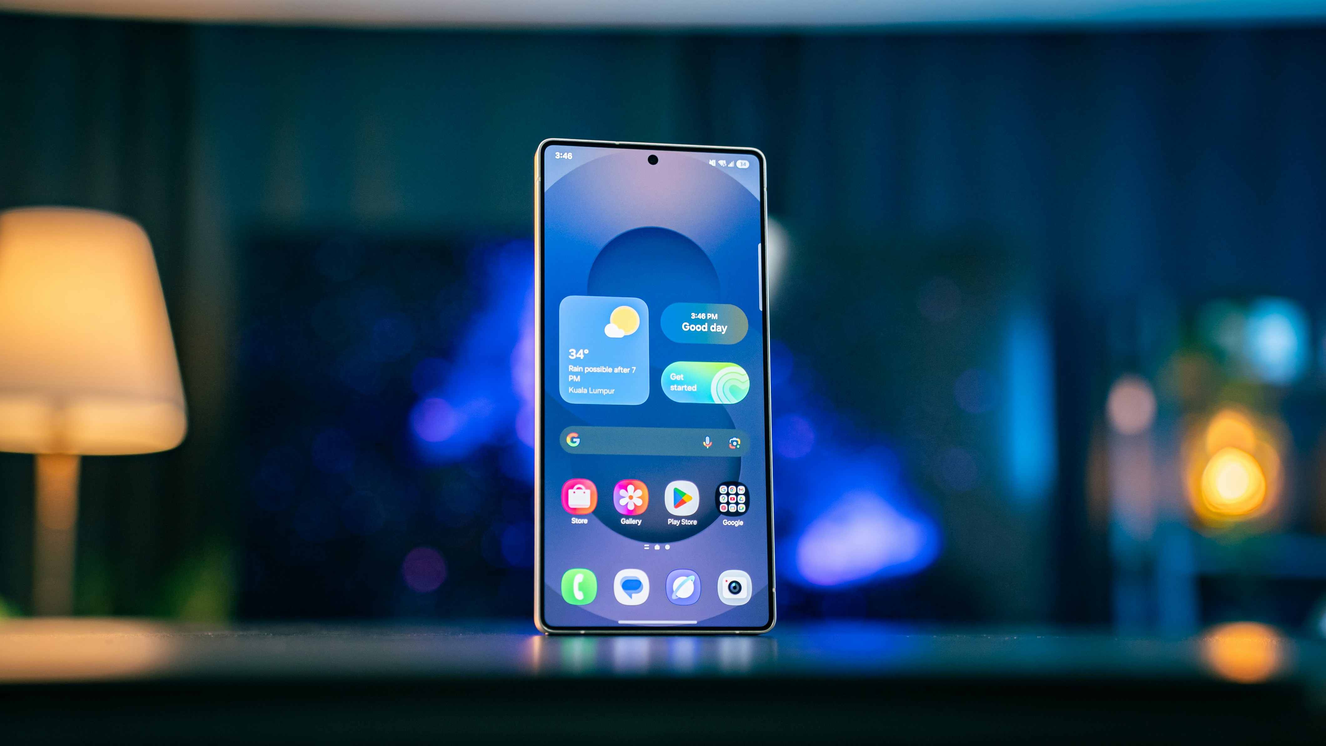 An Android phone standing upright on a table in a dimly lit room, showing its home screen