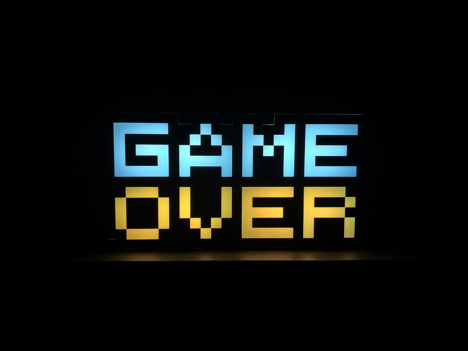 Retro pixel-art 'Game Over' light sign, evoking a blocked console-store purchase