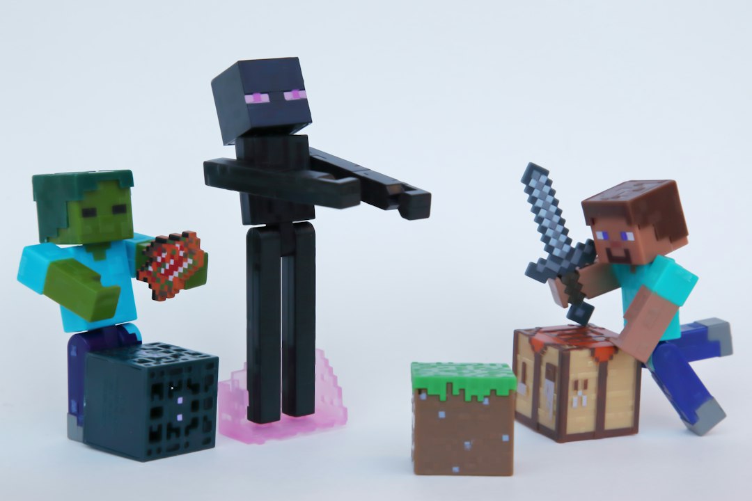 Minecraft toy figures of Steve, an Enderman and a zombie posed around block-shaped props on a white table