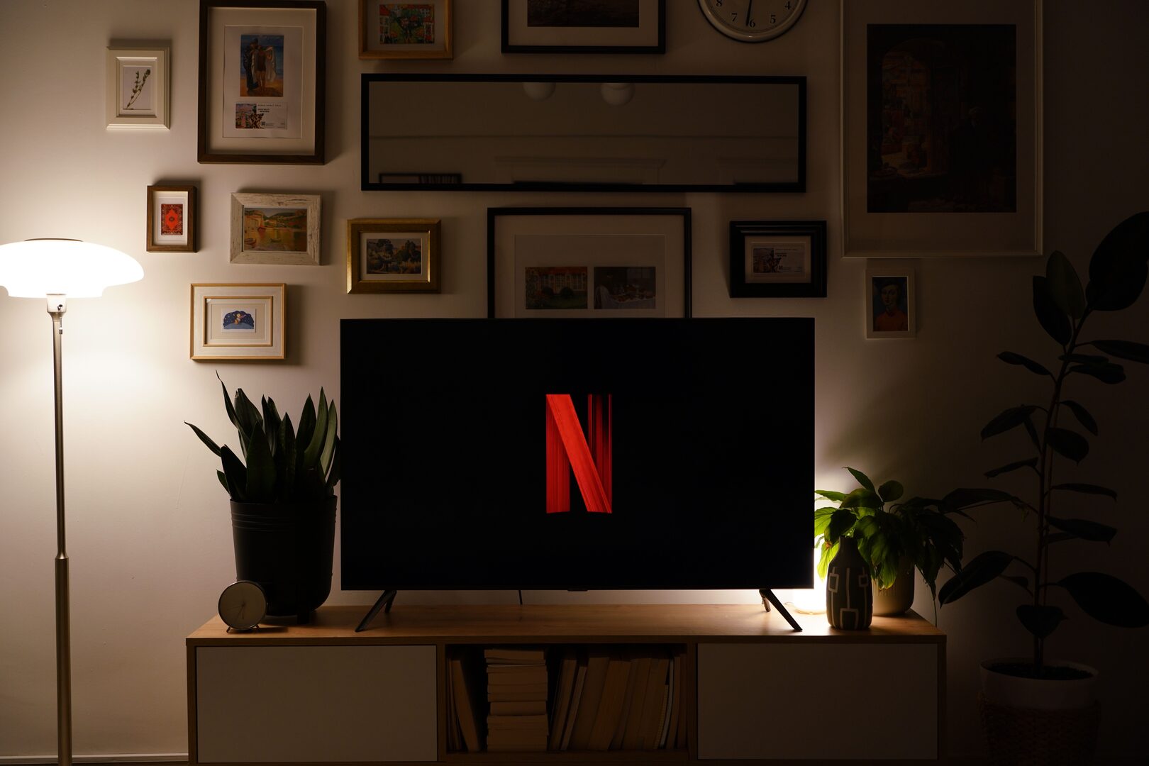 A television in a dimly lit living room showing the Netflix logo on an otherwise empty screen